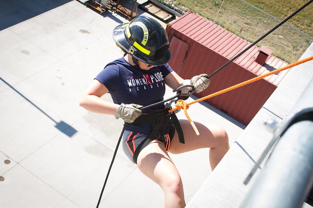 Aims fire science Xplore Academy student rappelling down a tower at the Public Safety Institute