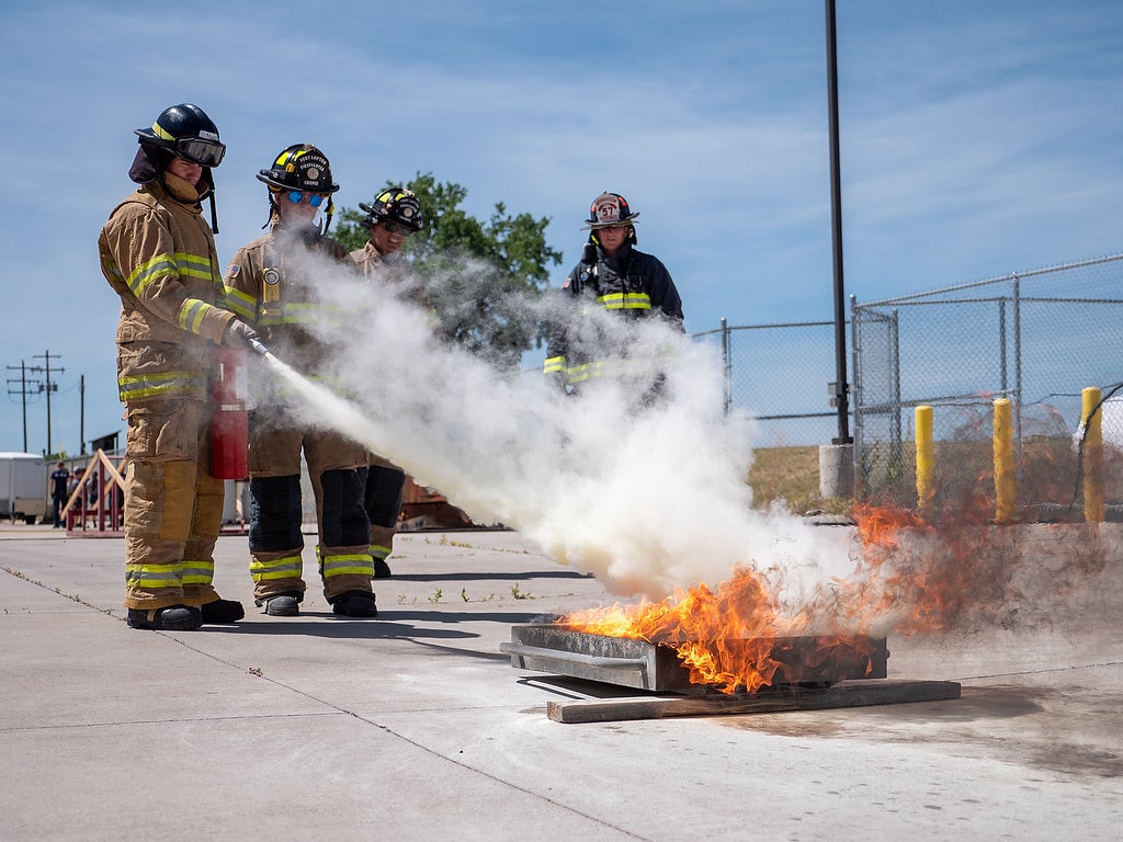Aims fire science Xplore Academy students putting out a fire during a simulation exercise