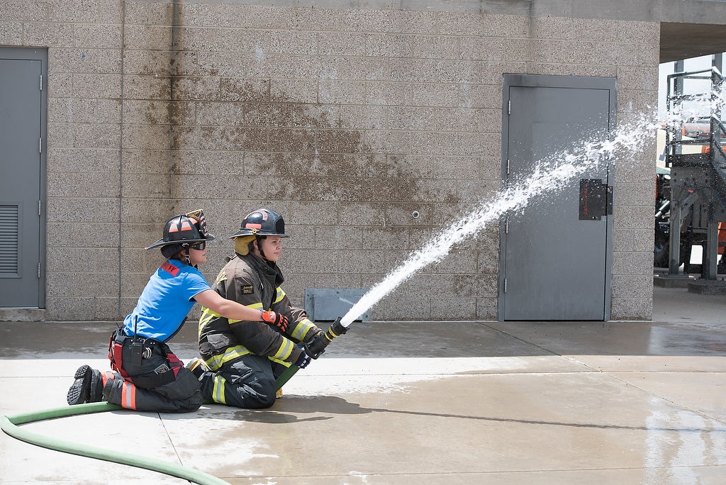 Aims fire science Xplore Academy students practicing using a fire hose