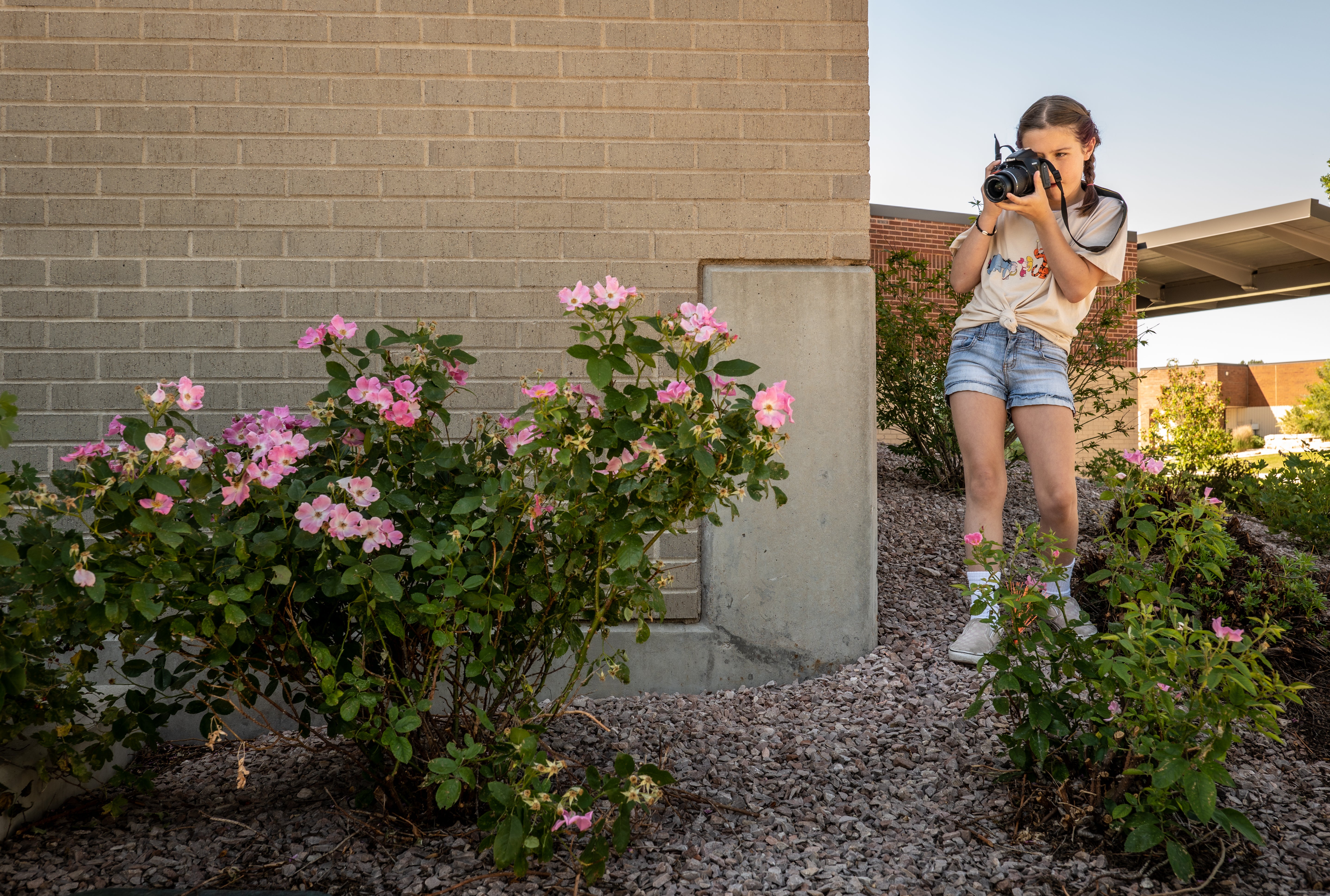 College for kids, girl taking photos of flowers