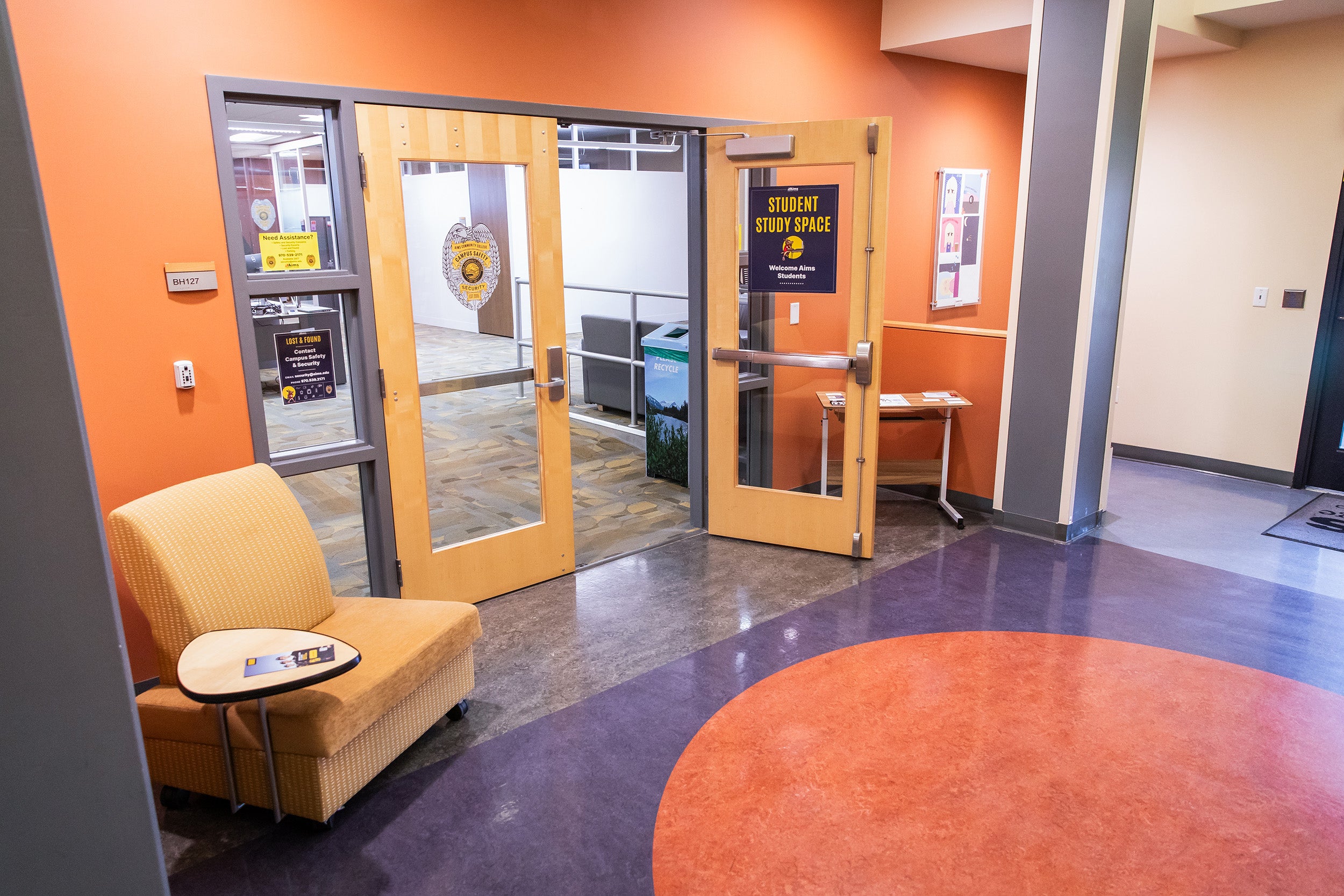 Exterior doors of the Campus Security office with a chair outside.