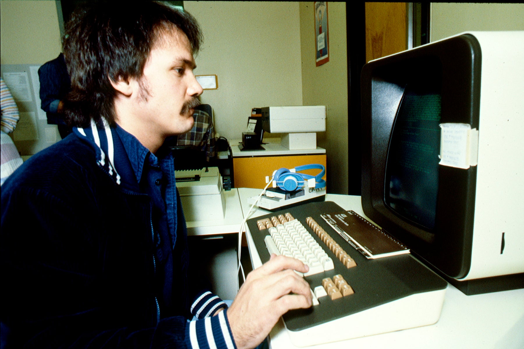 An Aims student using a computer in a graphic arts class in 1990.