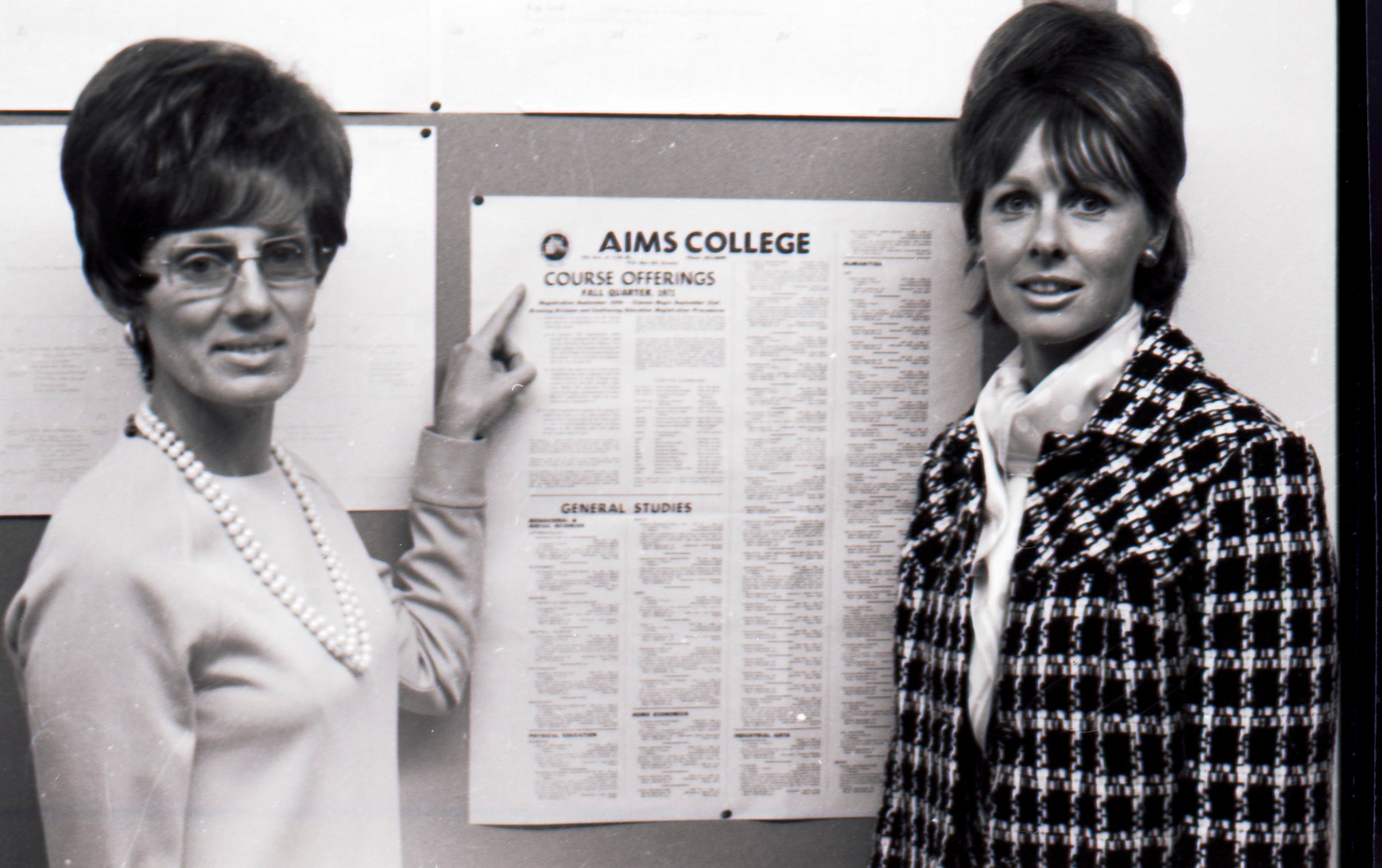 Aims Community College Business instructors with a board displaying course listings in 1971