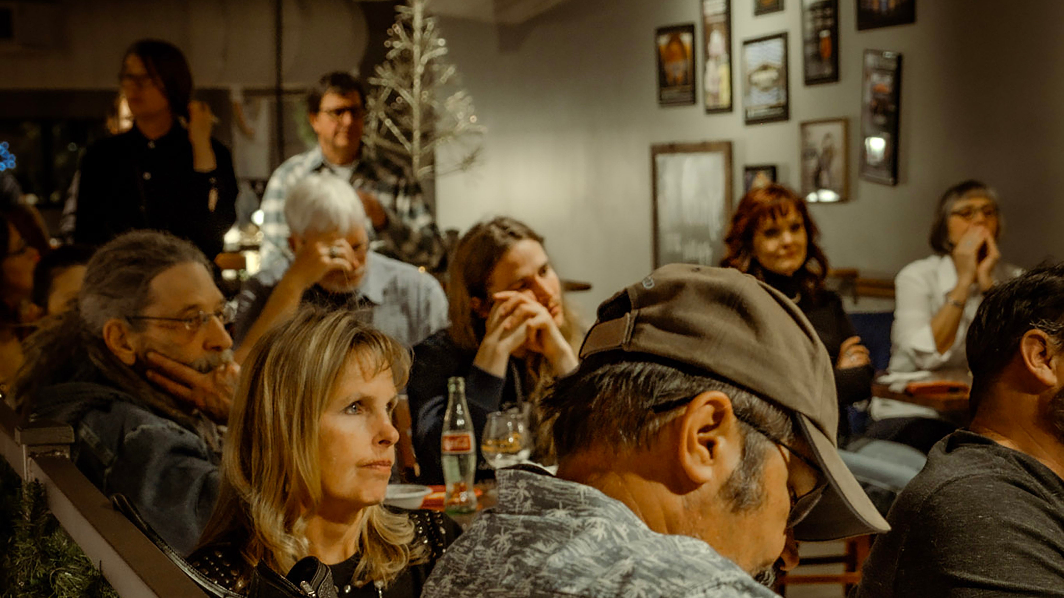 tavern full of people listening to someone read