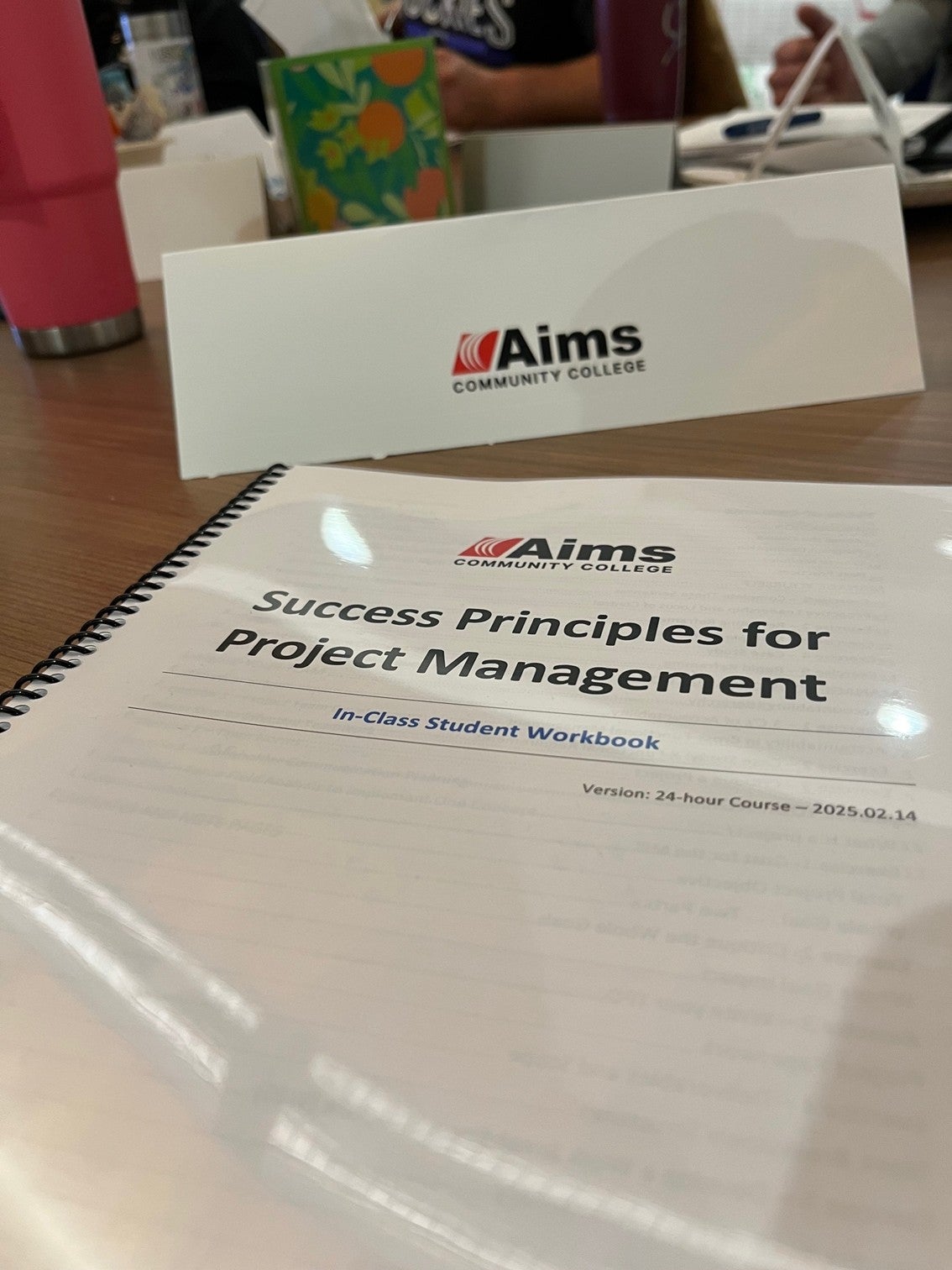 White workbook with black spiral binding titled &quot;Success Principles for Project Management&quot;