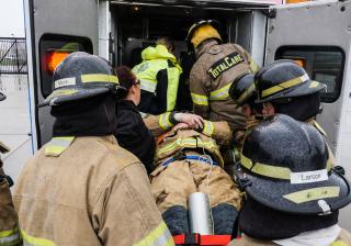 Emergency medical students loading a patient into an ambulance