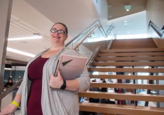 Student standing on stairs in Student Commons