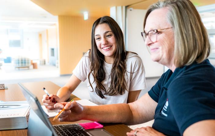 A student and a tutor working together on campus. 