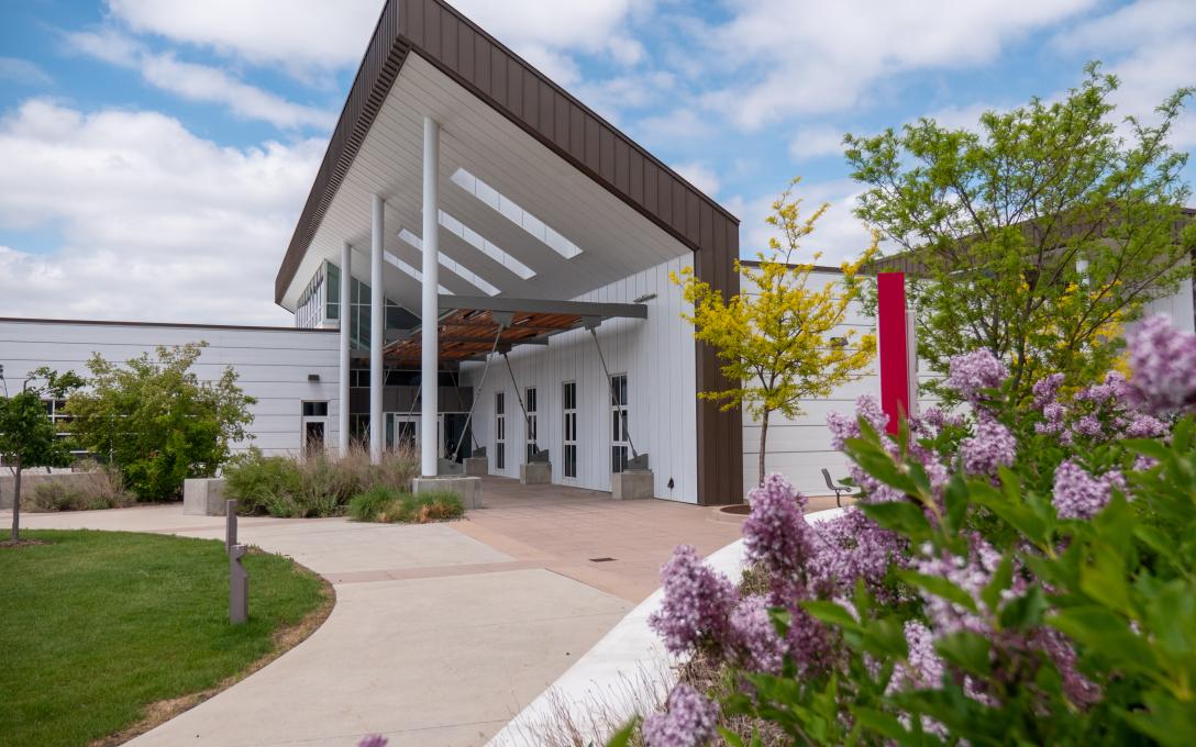 Exterior of the Platte Building on the Aims Fort Lupton campus, with lilacs in the foreground