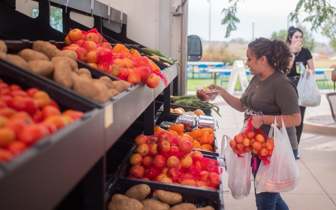 Farms to Families Food Truck with student choosing veggies