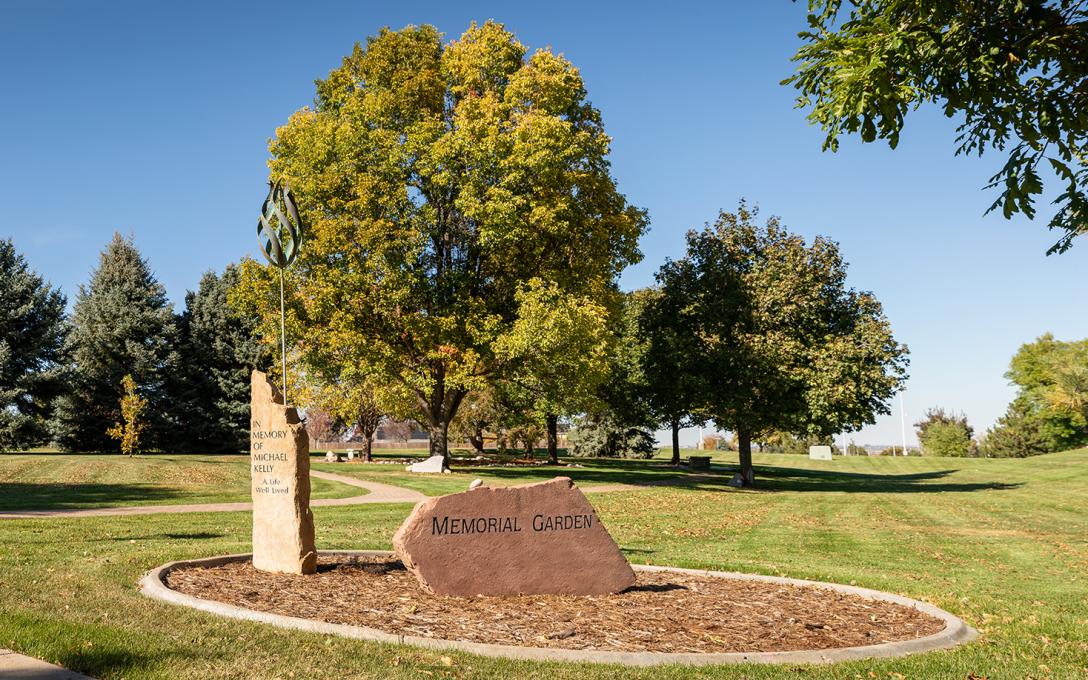 A memorial garden filled with trees and memorial stones and plaques.
