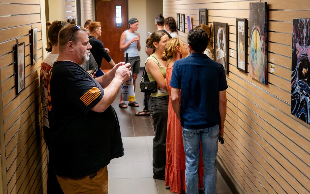 People looking at pictures and paintings at Aims art show