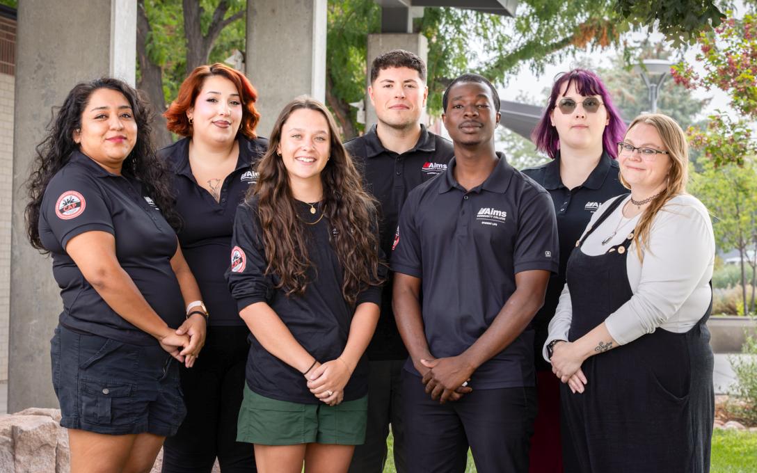 Group photo of the 2026-2027 Campus Activities Program Board in uniform standing outside smiling with their supervisor Danielle Irwin.