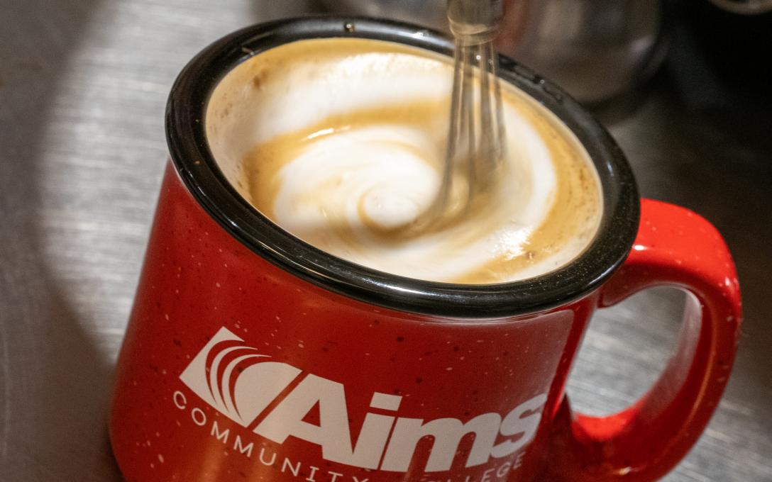 Red coffee mug with Aims logo