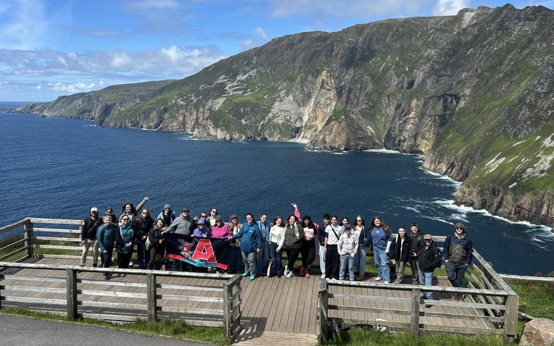 Study Abroad Group on Dock with water and hill