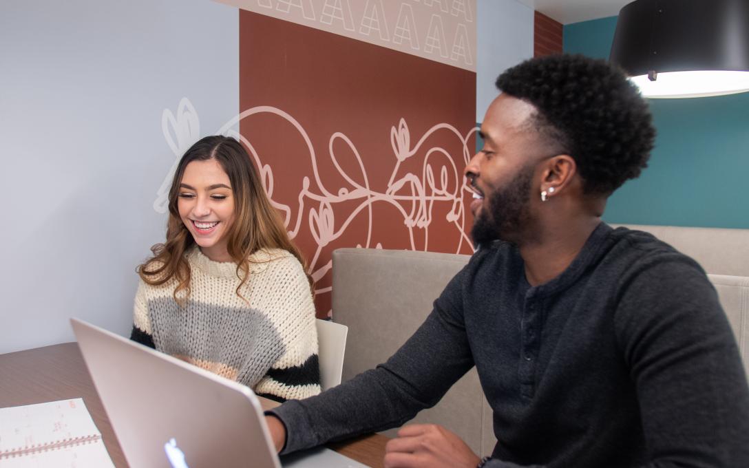 Students sitting at a table with a laptop
