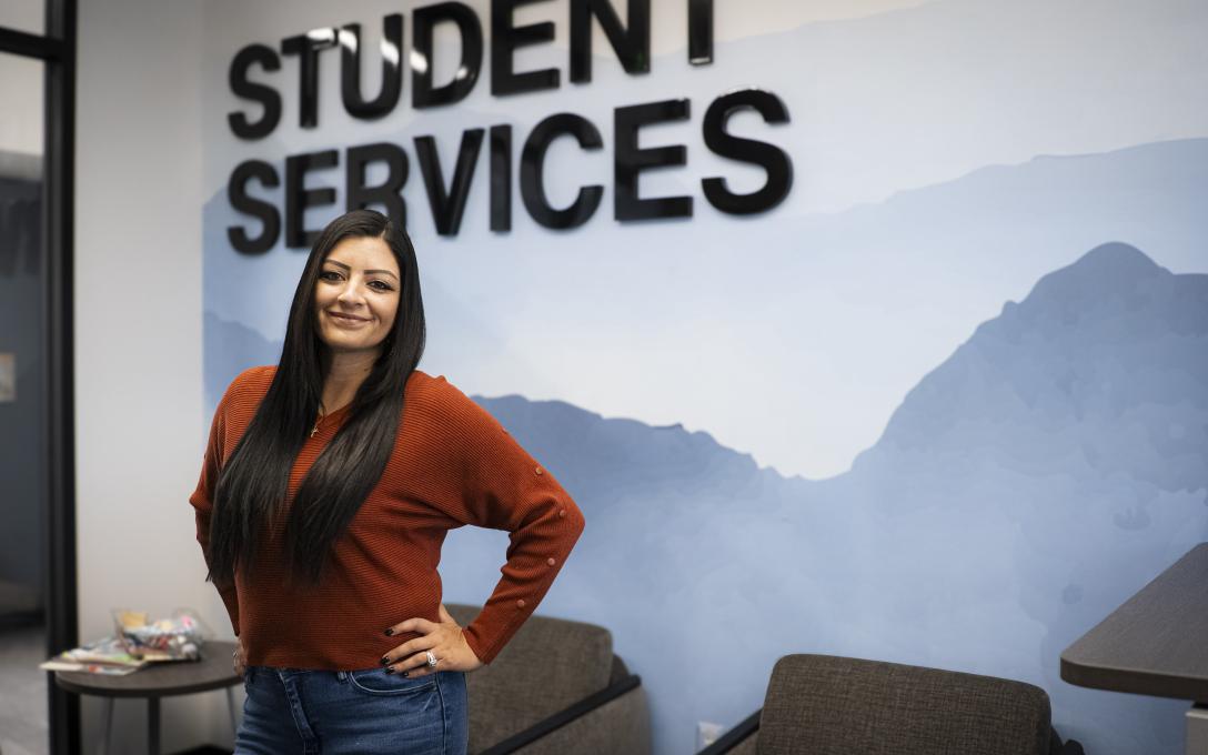 Darlene in front of a wall with Student Services sign