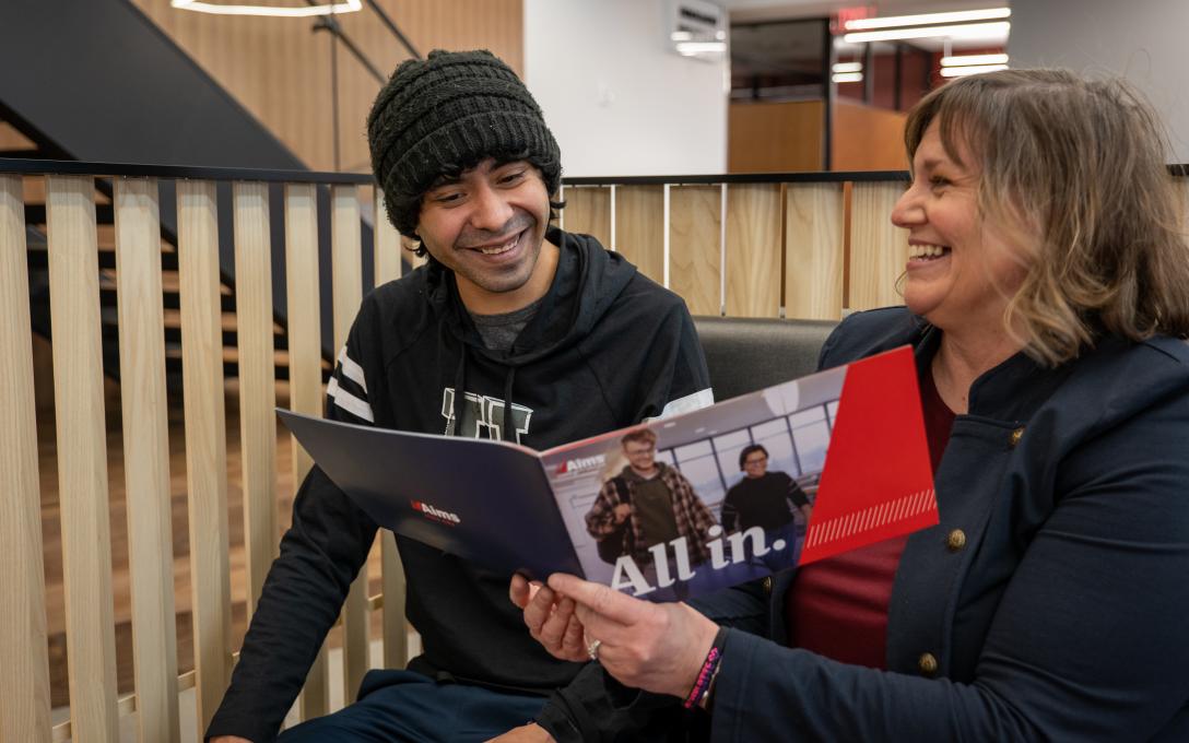 Admission Councilor showing student information in a book