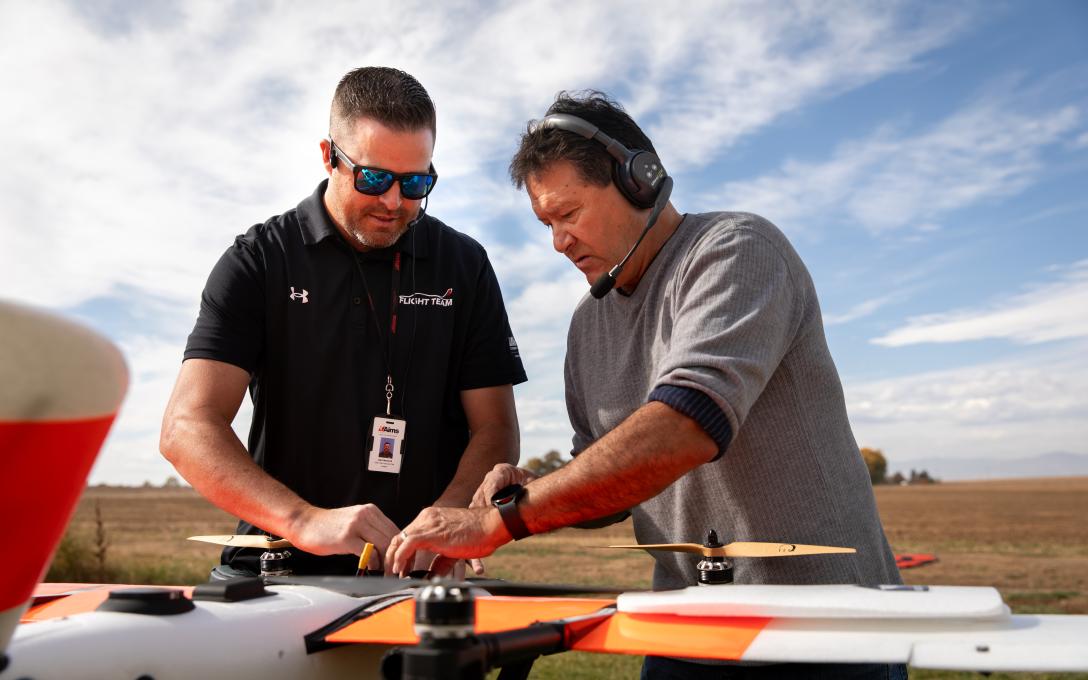 Aims UAS instructor Jacob Marshall working on a drone with a student