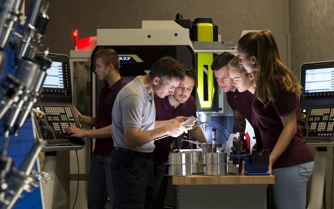 training taking place in a lab setting with participants looking at glass containers together