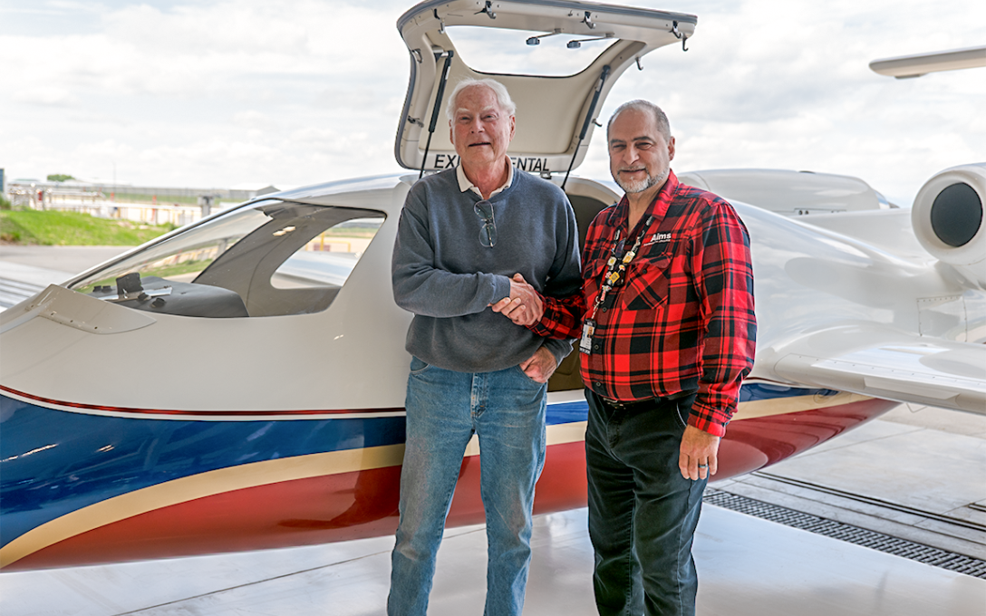 Two men standing by an airplane