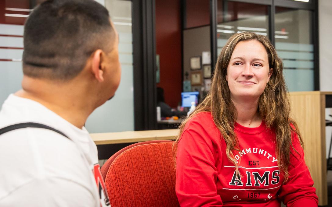 A Student Advising Mentor meets with a student in the lobby of the Advising office.