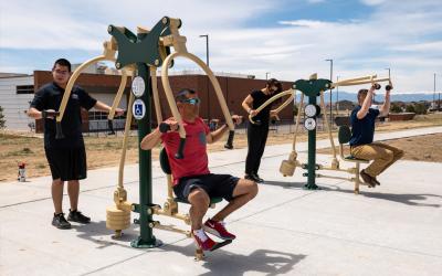 People using exercise equipment along the outdoor Fort Lupton Fitness Trail