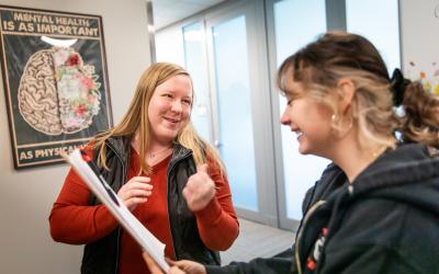 An Aims counselor and student look at paperwork together