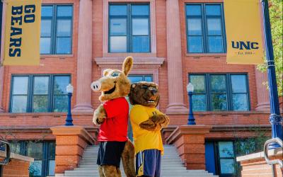 Aims mascot Arty the Aardvark standing with UNC mascot Klawz the Bear for the Aims2UNC Transition Program
