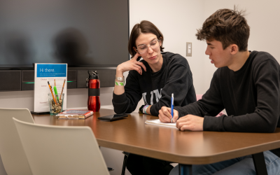 A student shows a tutor his writing