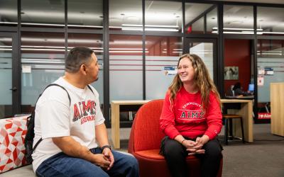 Aims staff member and student sit together in an office