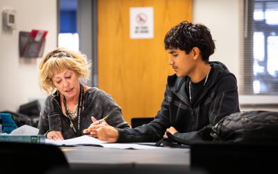 a student and advisor sitting at a table going over material