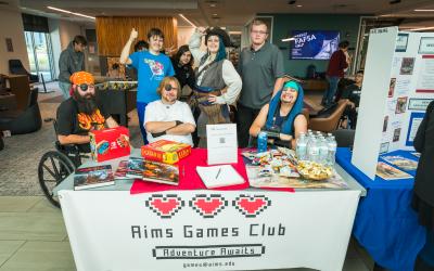 Aims games club students in costumes at club rush table 