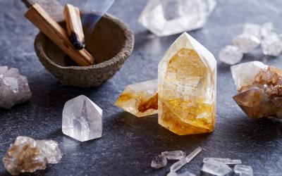 crystals on a table next to a small bowl with burning palo santo wood incense