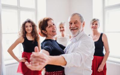 A middle-aged couple dancing while two teachers and another student look on