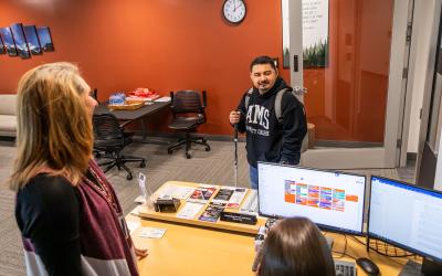 student with a white cane talking with disability access services staff