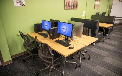 A table with PC and Mac computers for students in the Fort Lupton Learning Commons.