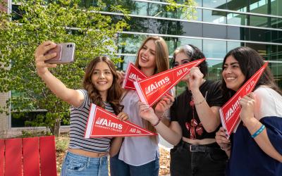 Aims students holding Aims All-In pennants in the Greeley Commons courtyard