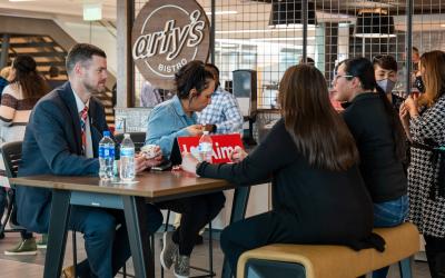 Aims students and faculty sitting at a table in Arty's bistro drinking coffee and talking