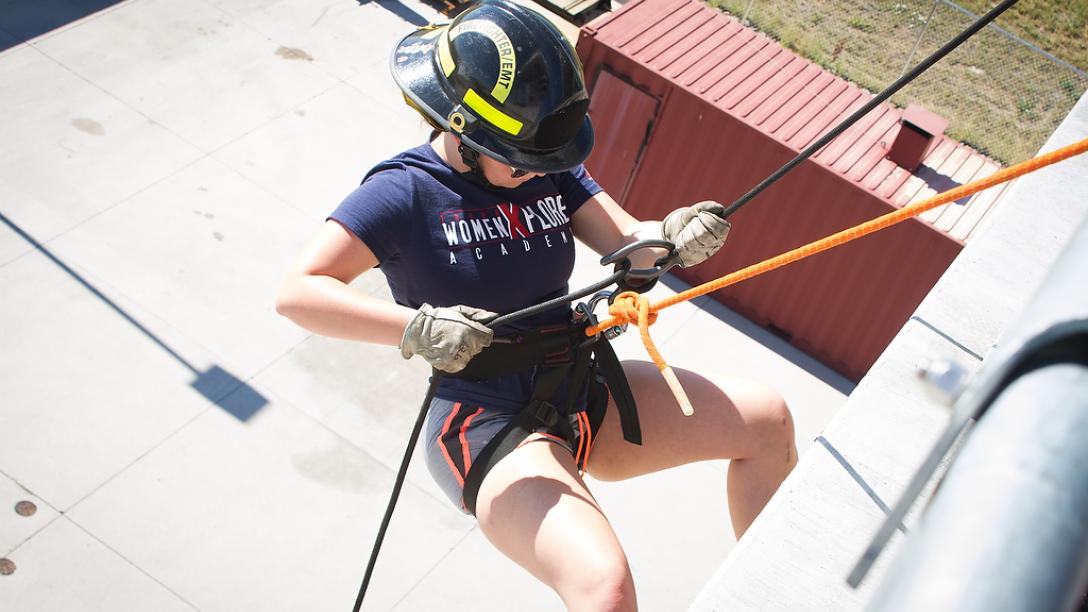 Aims fire science Xplore Academy student rappelling down a tower at the Public Safety Institute