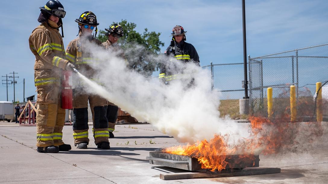 Aims fire science Xplore Academy students putting out a fire during a simulation exercise