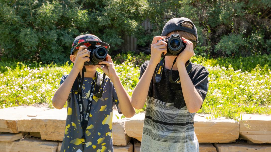 College for kids, two kids taking photos outside