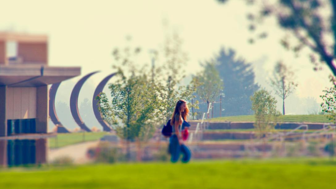 A student walking along the Aims Community College promenade