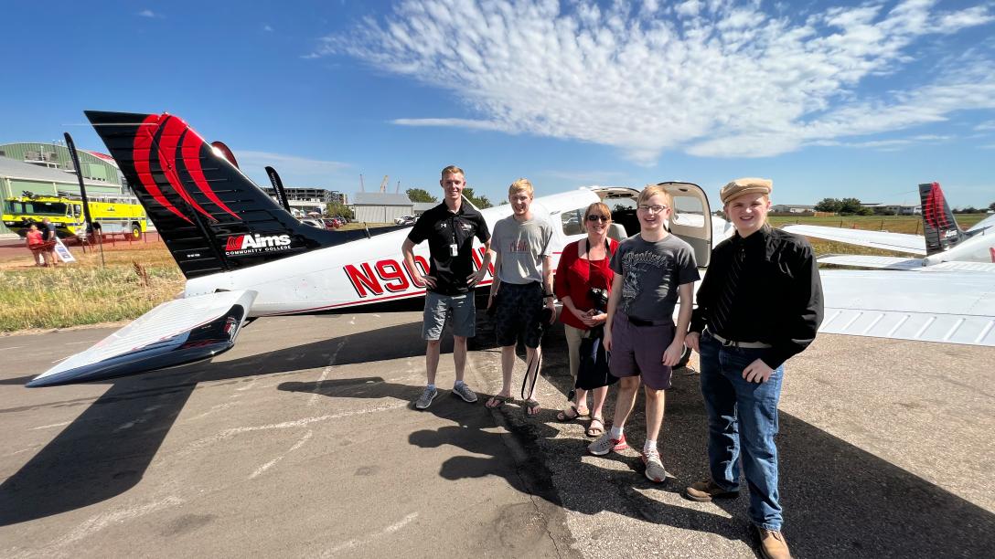 Group standing by airplane at Aviation Day