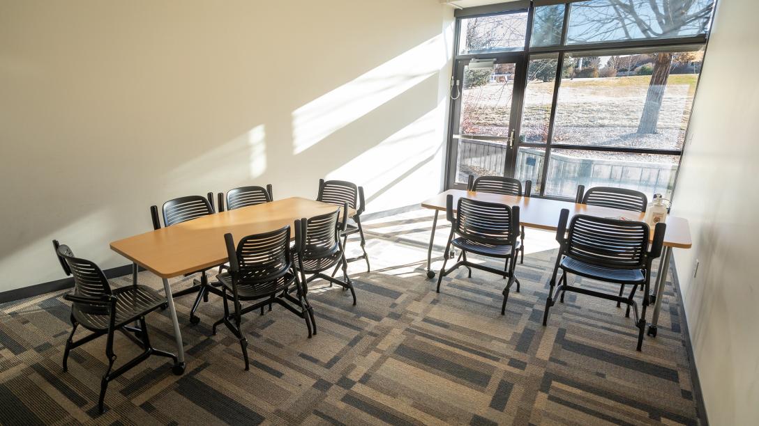 The interior of Horizon Hall study room 101 has tables and chairs for students to use.