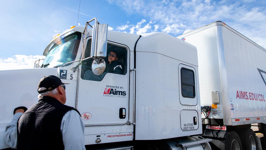 CDL trainer talks to student in truck