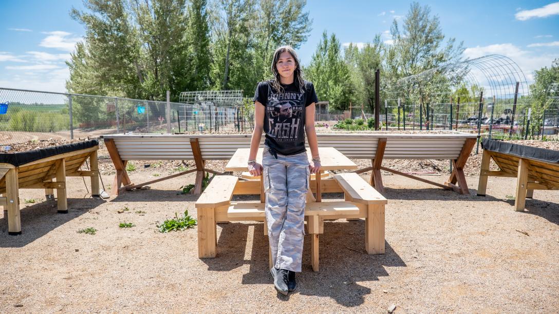 Keira Zabel and the picnic table she created at Loveland Youth Gardeners youth-led farm.