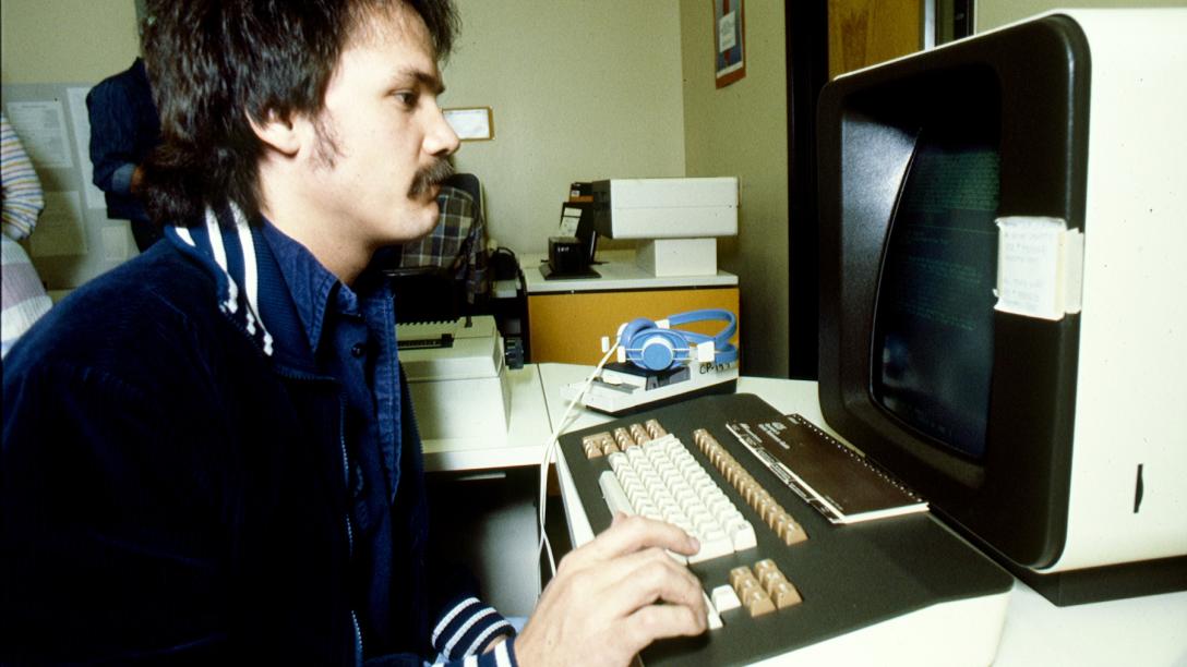 An Aims student using a computer in a graphic arts class in 1990.