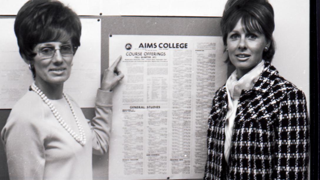 Aims Community College Business instructors with a board displaying course listings in 1971