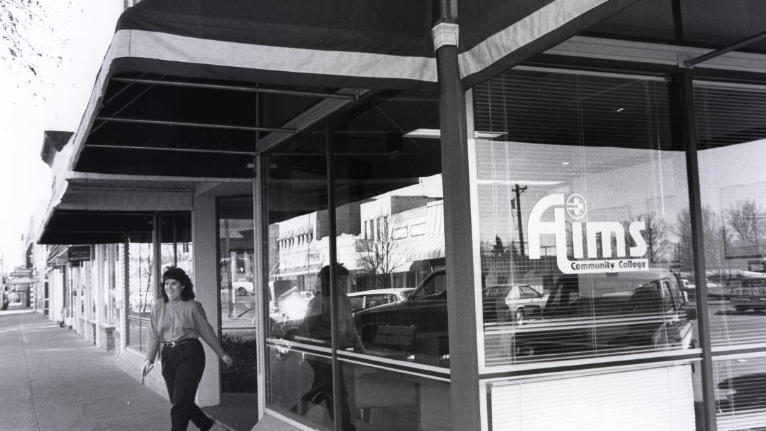 A person standing in front of the Loveland Campus building in downtown Loveland, Colorado in 1995.